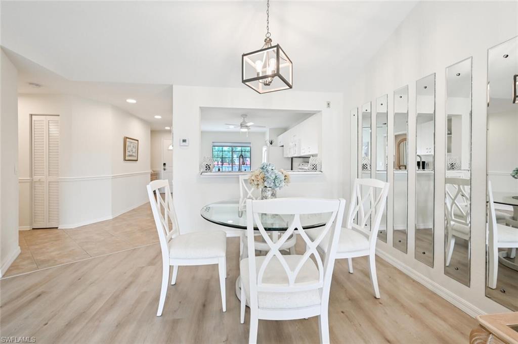 515 Gabriel Circle, Unit 1910 Naples, FL 34104 - Photo 5 of 29 a view of a dining room with furniture and wooden floor