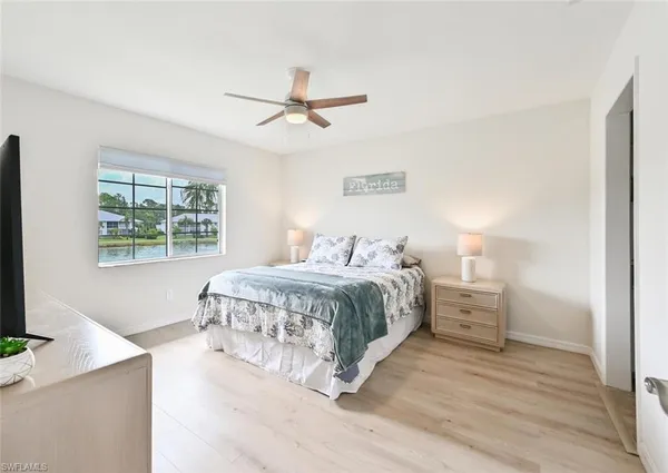 a spacious bedroom with a large bed and a chandelier