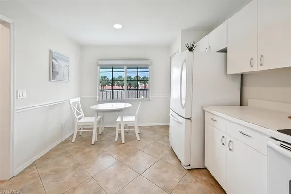 a kitchen with stainless steel appliances a refrigerator a stove a dining table and chairs