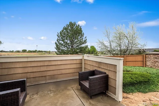 a view of terrace with lawn chairs and wooden fence