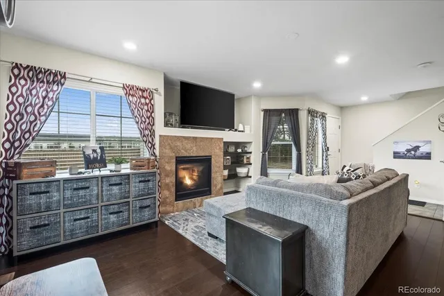 a living room with furniture a flat screen tv and a fireplace