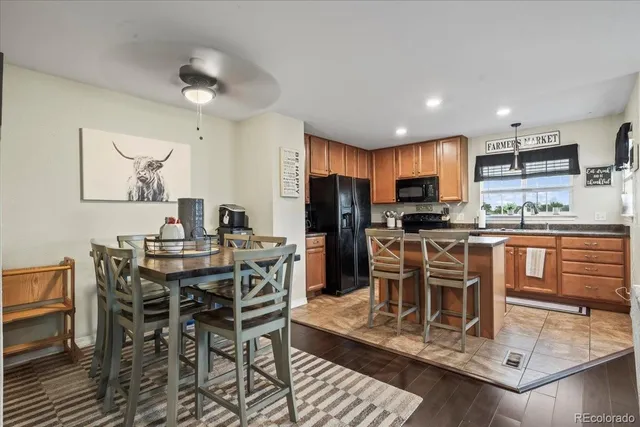 a kitchen with stainless steel appliances kitchen island granite countertop a dining table chairs and granite counter tops