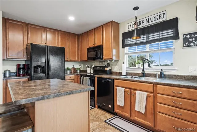 a kitchen with granite countertop stainless steel appliances a refrigerator stove top oven and sink