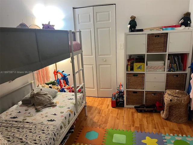 a bedroom with bed and wooden floor