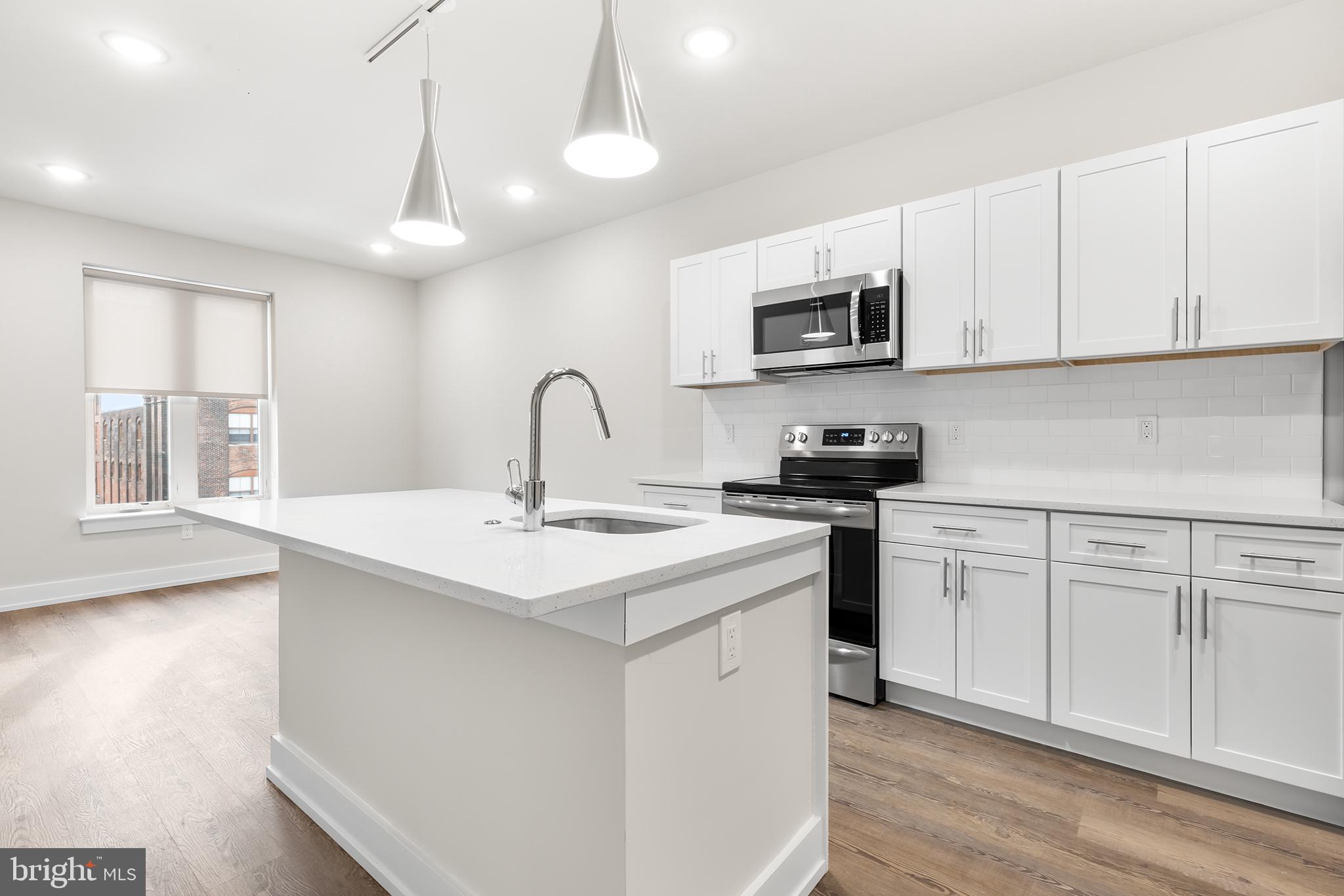 214 Vine Street, Unit 604 Philadelphia, PA 19106 - Photo 20 of 35 a kitchen with stainless steel appliances granite countertop a sink a stove a microwave and cabinets