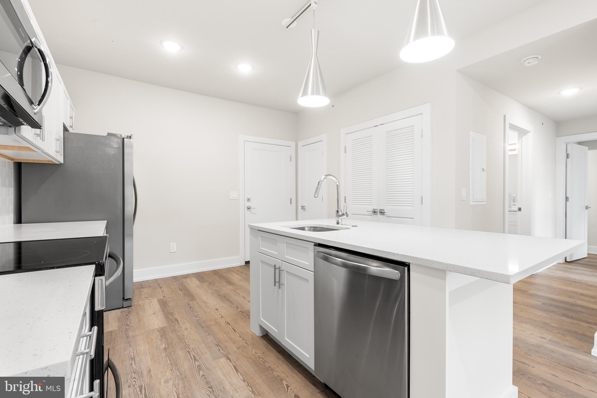 214 Vine Street, Unit 604 Philadelphia, PA 19106 - Photo 24 of 35 a kitchen with stainless steel appliances granite countertop a sink a stove a refrigerator and island with wooden floor