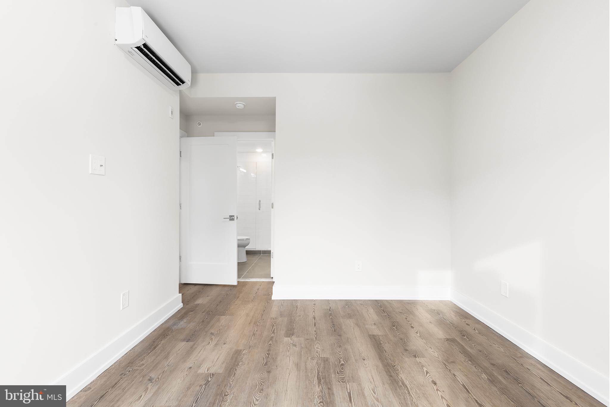 214 Vine Street, Unit 604 Philadelphia, PA 19106 - Photo 32 of 35 a view of an empty room with wooden floor and a window