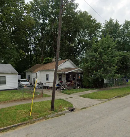 a front view of a house with a yard and trees