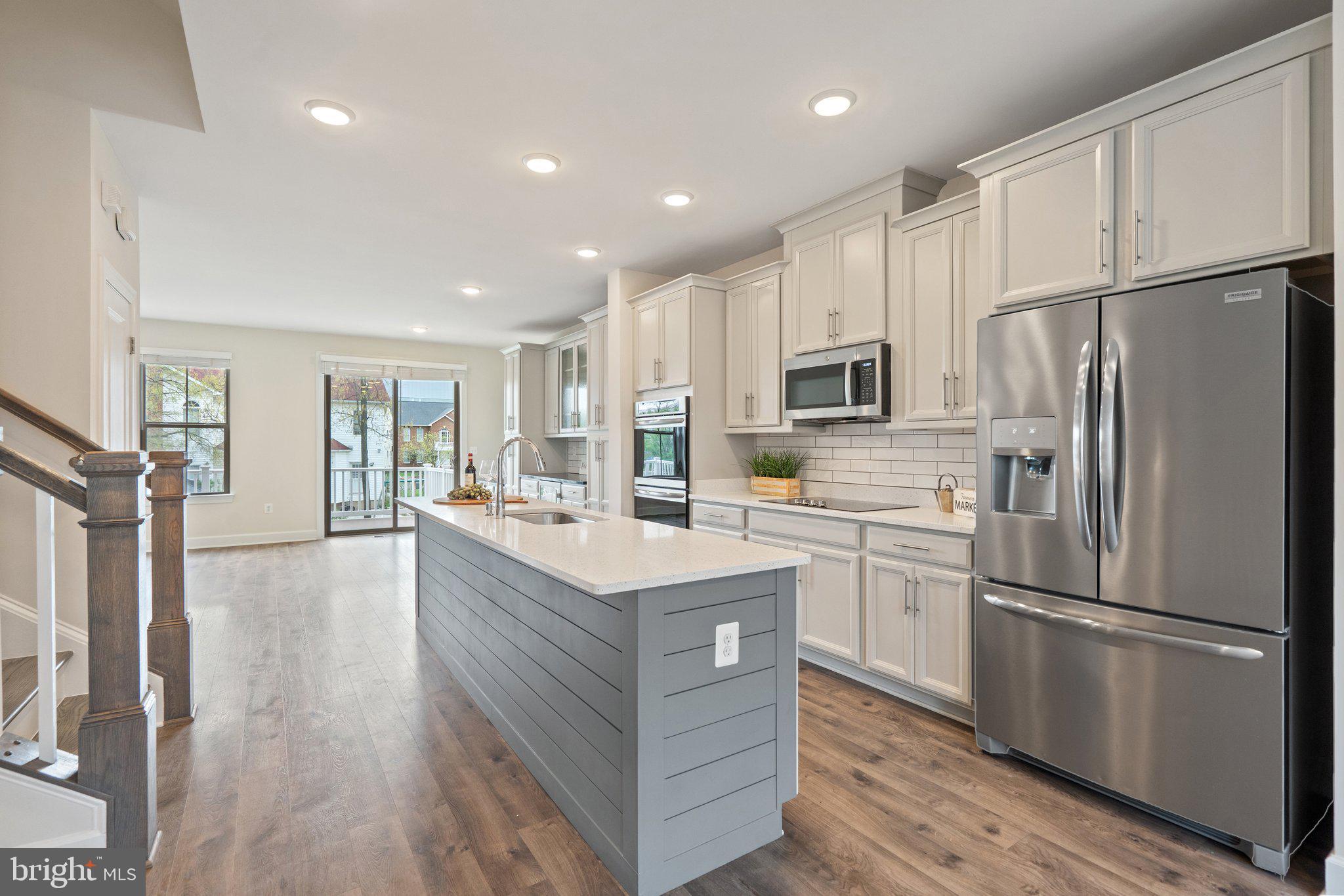 45397 Daveno Square Sterling, VA 20164 - Photo 2 of 44 a kitchen with kitchen island white cabinets and stainless steel appliances