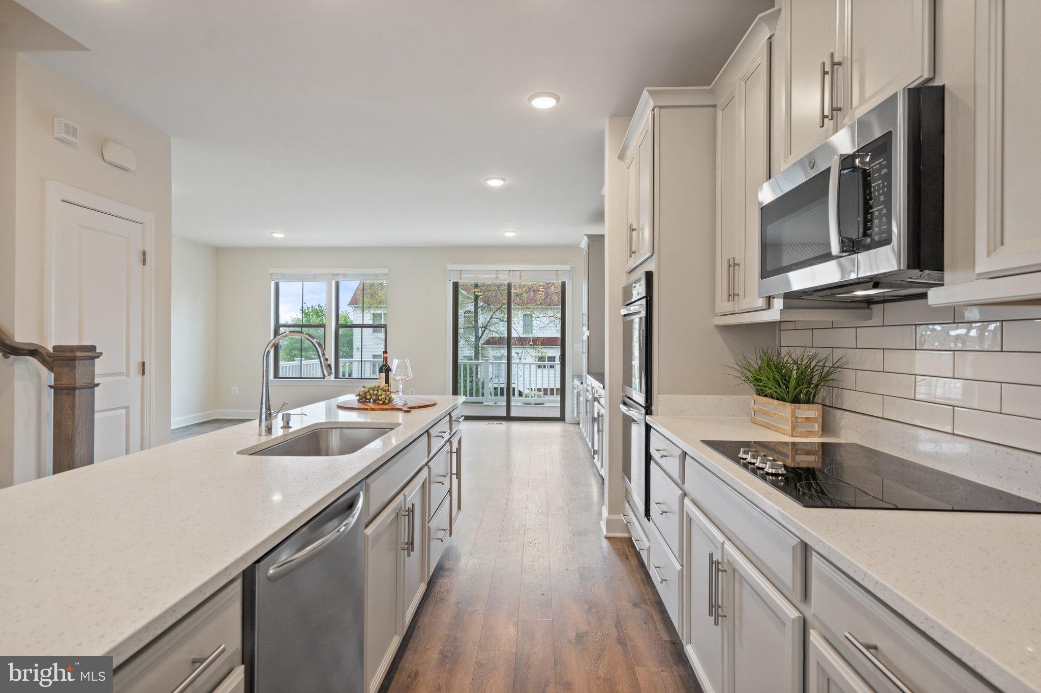 45397 Daveno Square Sterling, VA 20164 - Photo 3 of 44 a large kitchen with stainless steel appliances a sink a stove and a wooden floors
