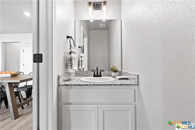 a bathroom with a granite countertop sink and a mirror