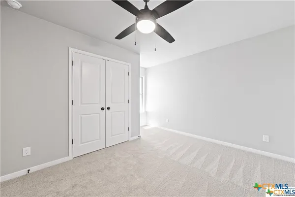an empty room with chandelier fan