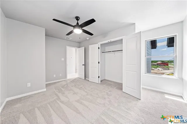 a view of a livingroom with a ceiling fan and window