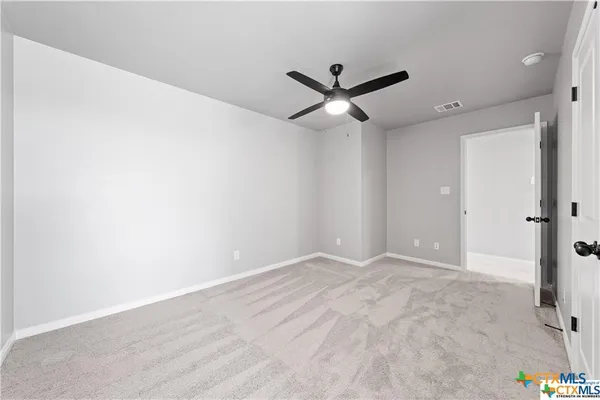 an empty room with a ceiling fan and a window