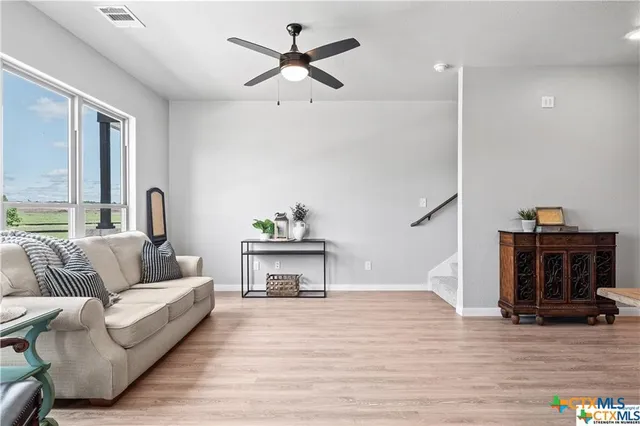 a living room with furniture and a wooden floor