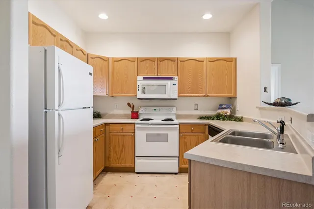a kitchen with a refrigerator sink and cabinets