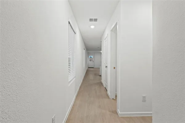 a view of a hallway with wooden floor