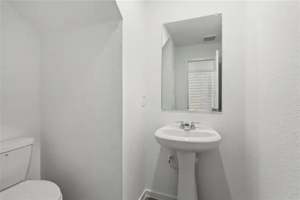 a bathroom with a sink a toilet and mirror