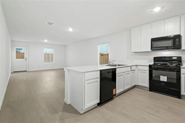 a kitchen with a sink and steel appliances