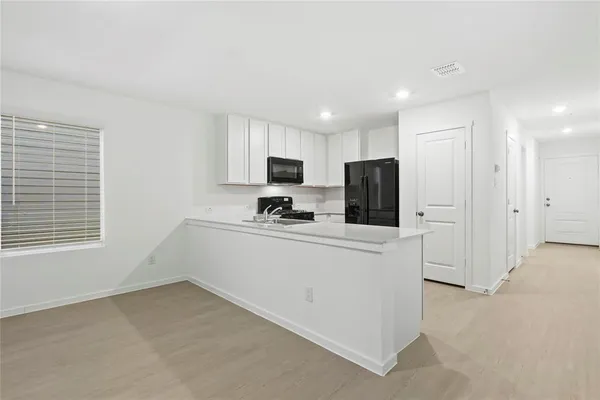 a kitchen with white cabinets and stainless steel appliances