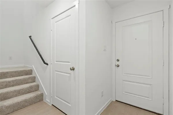 a view of staircase with white walls and empty room
