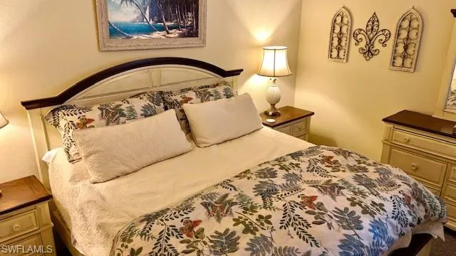 a bedroom with a bed and painting on the wall