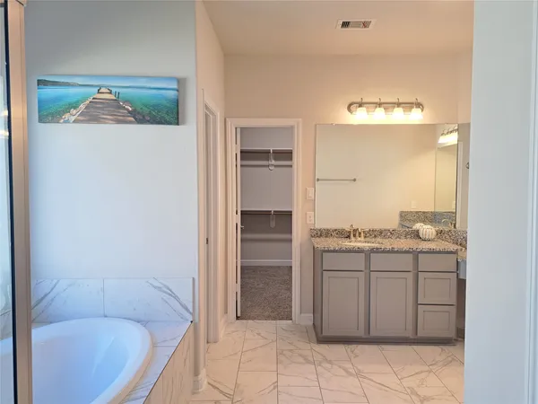 a bathroom with a tub sink and mirror