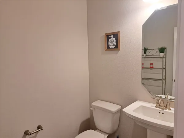 a bathroom with a toilet a sink and mirror