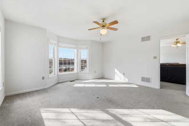 a view of a livingroom with a ceiling fan and window