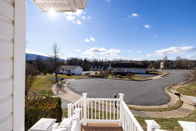 a view of a balcony with wooden floor and fence