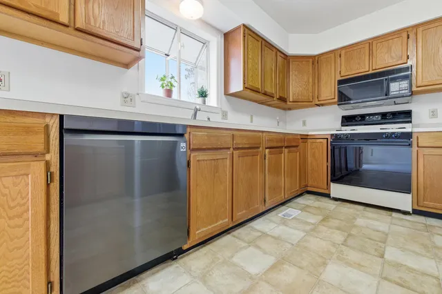 a kitchen with stainless steel appliances granite countertop a refrigerator and a sink