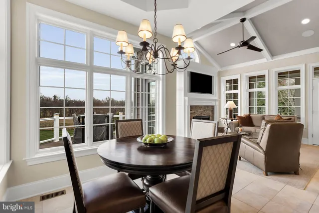 a dining room with furniture a chandelier and wooden floor