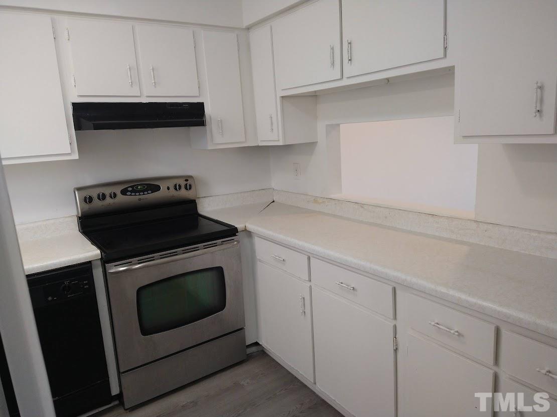 4240 Lake Ridge Drive, Unit 4240 Raleigh, NC 27604 - Photo 7 of 20 a kitchen with a stove and white cabinets
