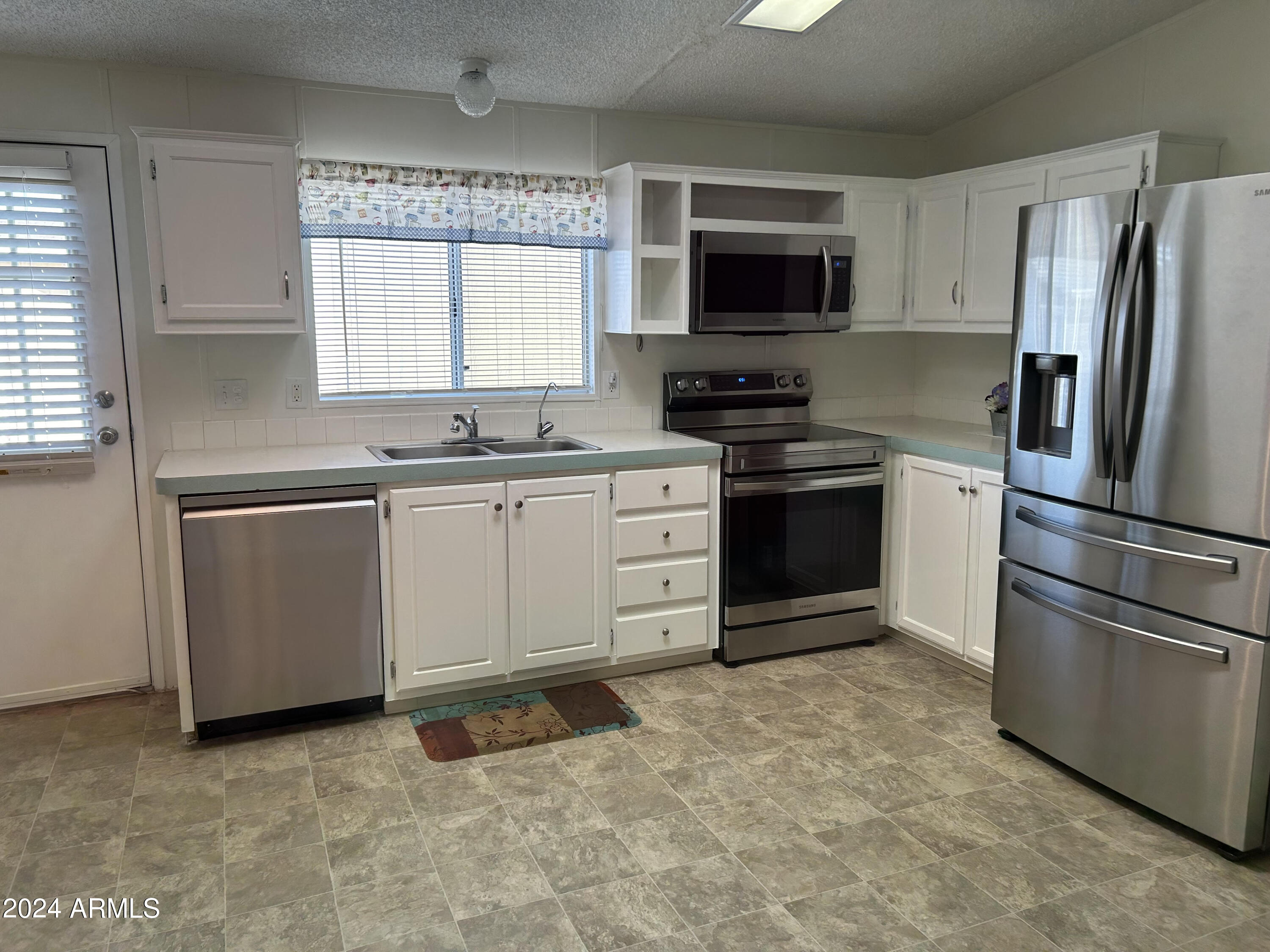 301 South Signal Butte Road, Unit 938 Apache Junction, AZ 85120 - Photo 4 of 11 a kitchen with stainless steel appliances granite countertop a stove a sink and a refrigerator