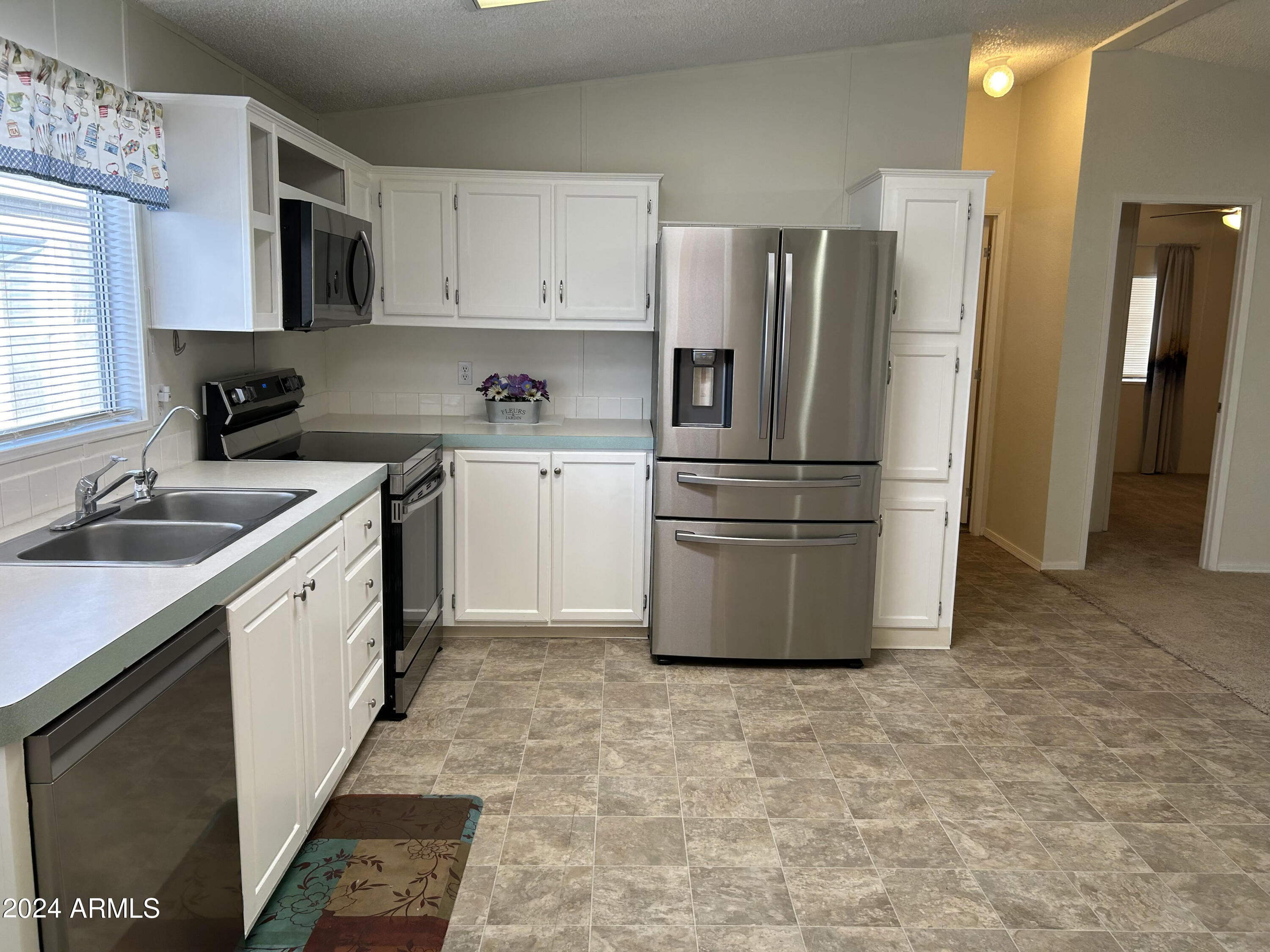 301 South Signal Butte Road, Unit 938 Apache Junction, AZ 85120 - Photo 5 of 11 a kitchen with granite countertop a refrigerator stove and sink