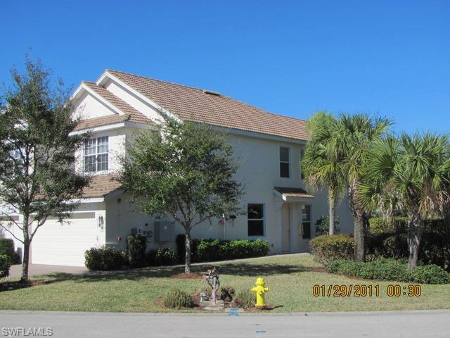 15570 Marcello Circle, Unit 149 Naples, FL 34110 - Photo 2 of 3 a front view of a house with a garden and tree