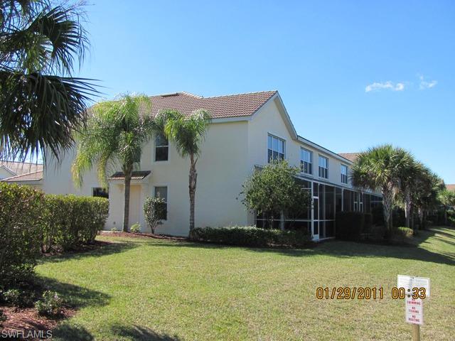 15570 Marcello Circle, Unit 149 Naples, FL 34110 - Photo 3 of 3 a backyard of a house with potted plants and palm tree