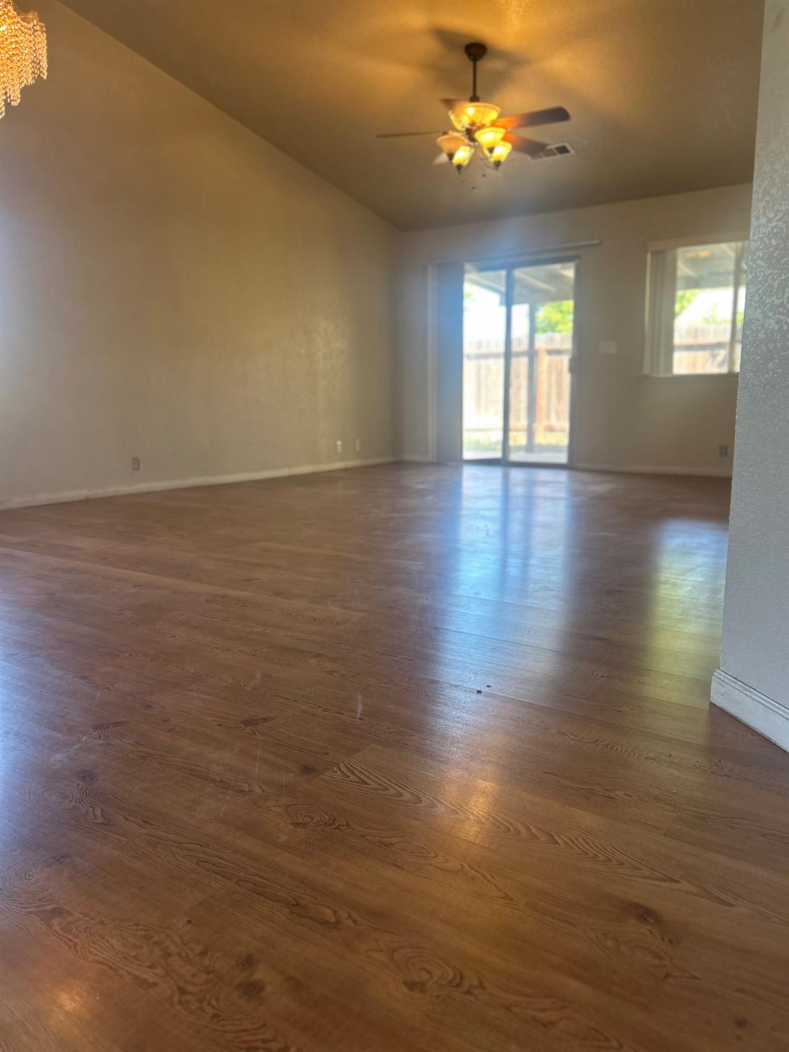 3421 Penny Lane Modesto, CA 95354 - Photo 4 of 12 an empty room with wooden floor and windows