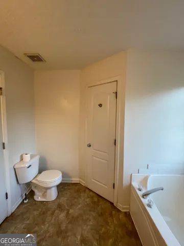 a bathroom with a tub and toilet