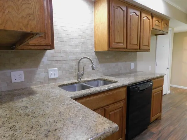 a kitchen with stainless steel appliances granite countertop a sink stove and cabinets