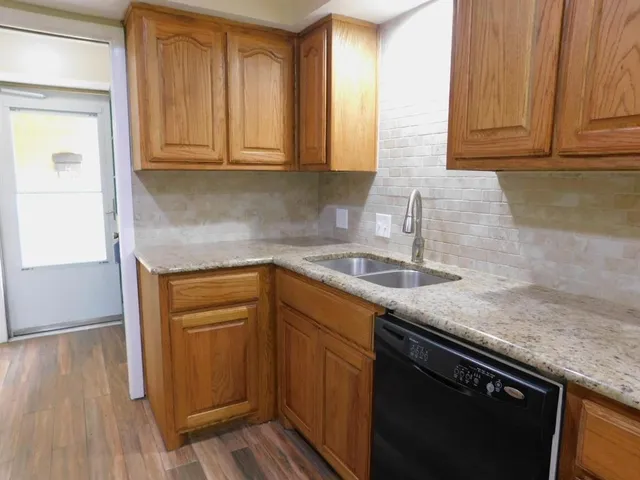 a kitchen with stainless steel appliances granite countertop a sink stove and cabinets