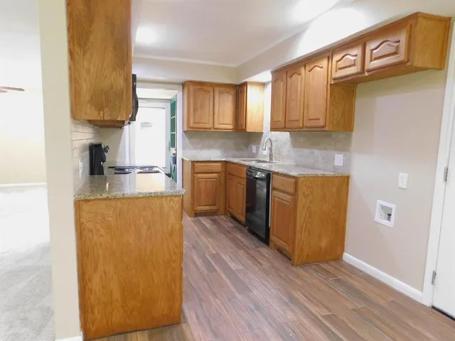 a kitchen with stainless steel appliances granite countertop a sink a stove and a refrigerator