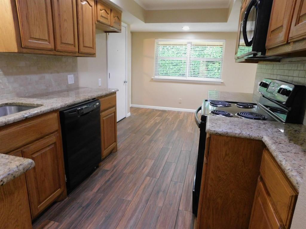 1301 Doncaster Street Irving, TX 75062 - Photo 10 of 19 a kitchen with granite countertop wooden floors wooden cabinets a stove and a sink