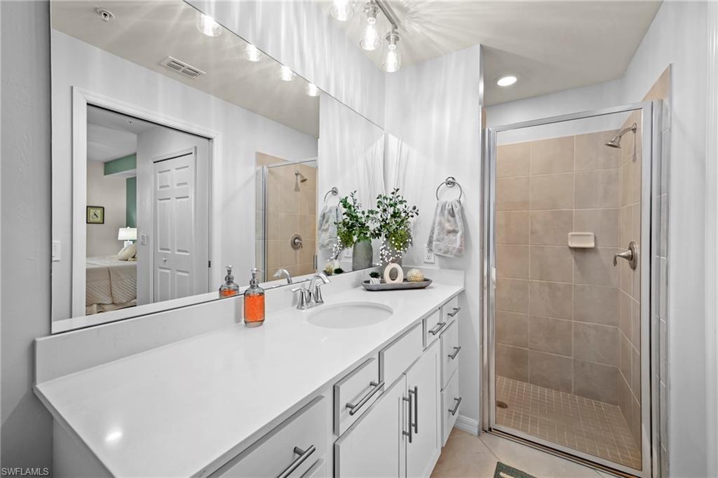 43993 Boardwalk Loop, Unit 1915 Babcock Ranch, FL 33982 - Photo 13 of 26 a bathroom with a sink vanity granite tub shower and a mirror