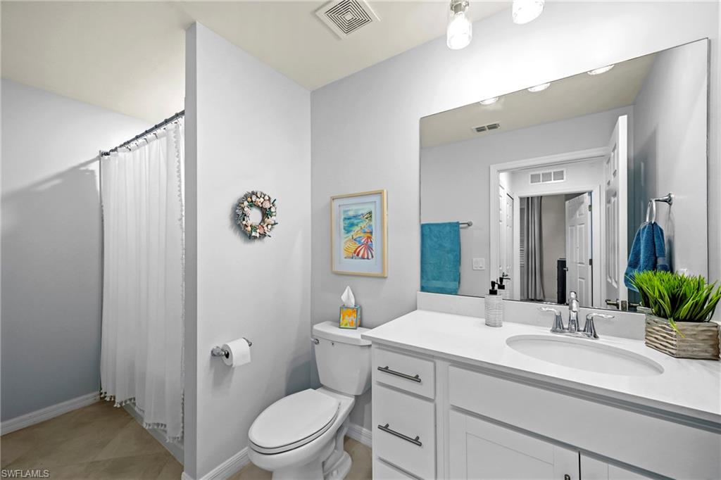 43993 Boardwalk Loop, Unit 1915 Babcock Ranch, FL 33982 - Photo 17 of 26 a bathroom with a sink vanity granite toilet and a mirror