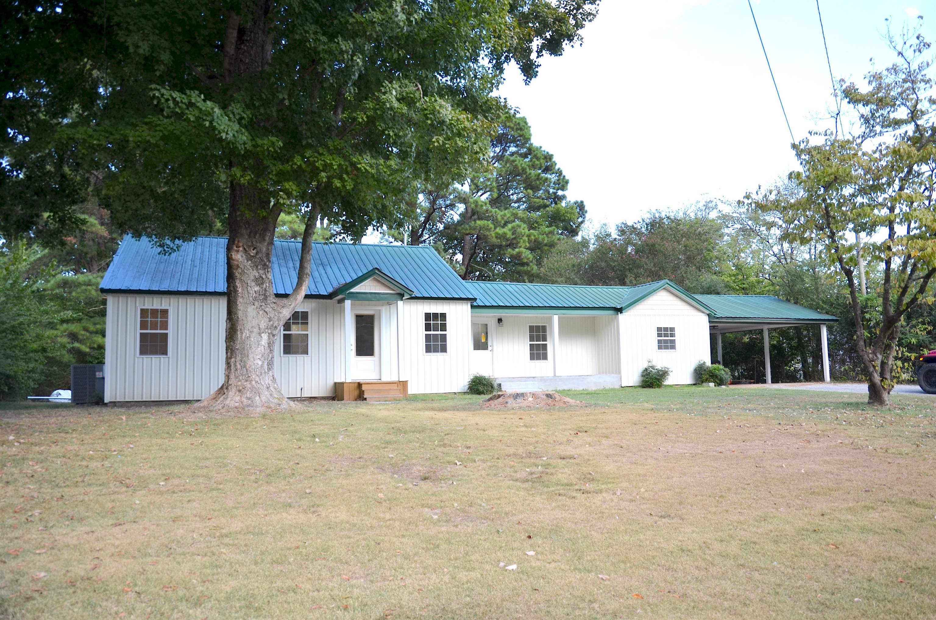 2464 Edith-Nankipoo Road Ripley, TN 38063 - Photo 2 of 22 White board and batten siding with a green metal roof, covered entryway, and an attached carport
