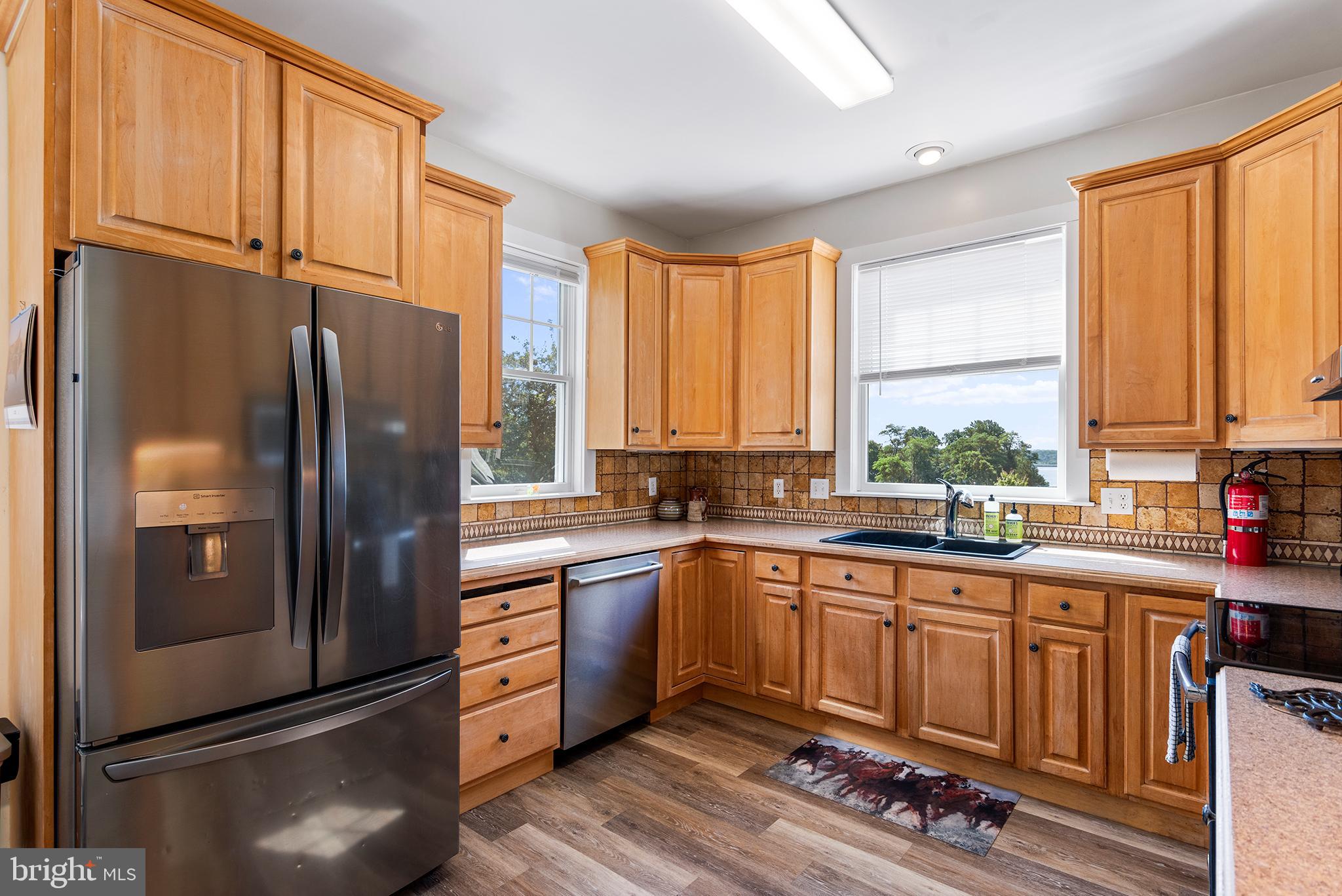 137 Elk Ranch Park Road Elkton, MD 21921 - Photo 13 of 52 a kitchen with stainless steel appliances granite countertop a refrigerator a sink dishwasher a stove and white cabinets with wooden floor