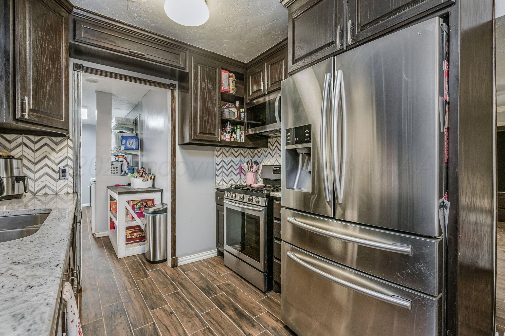 5326 Allen Street Amarillo, TX 79110 - Photo 6 of 17 a kitchen with stainless steel appliances a refrigerator and a stove