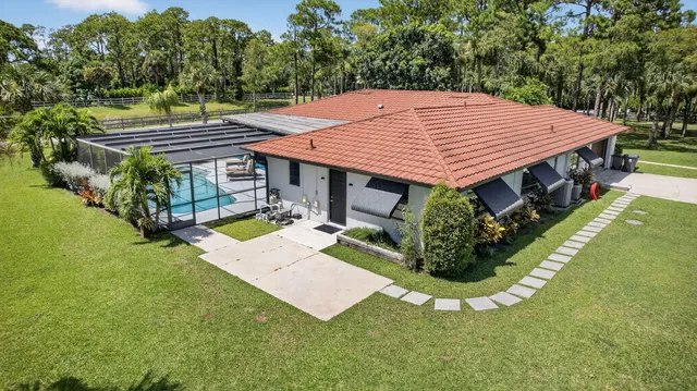an aerial view of a house with swimming pool and garden