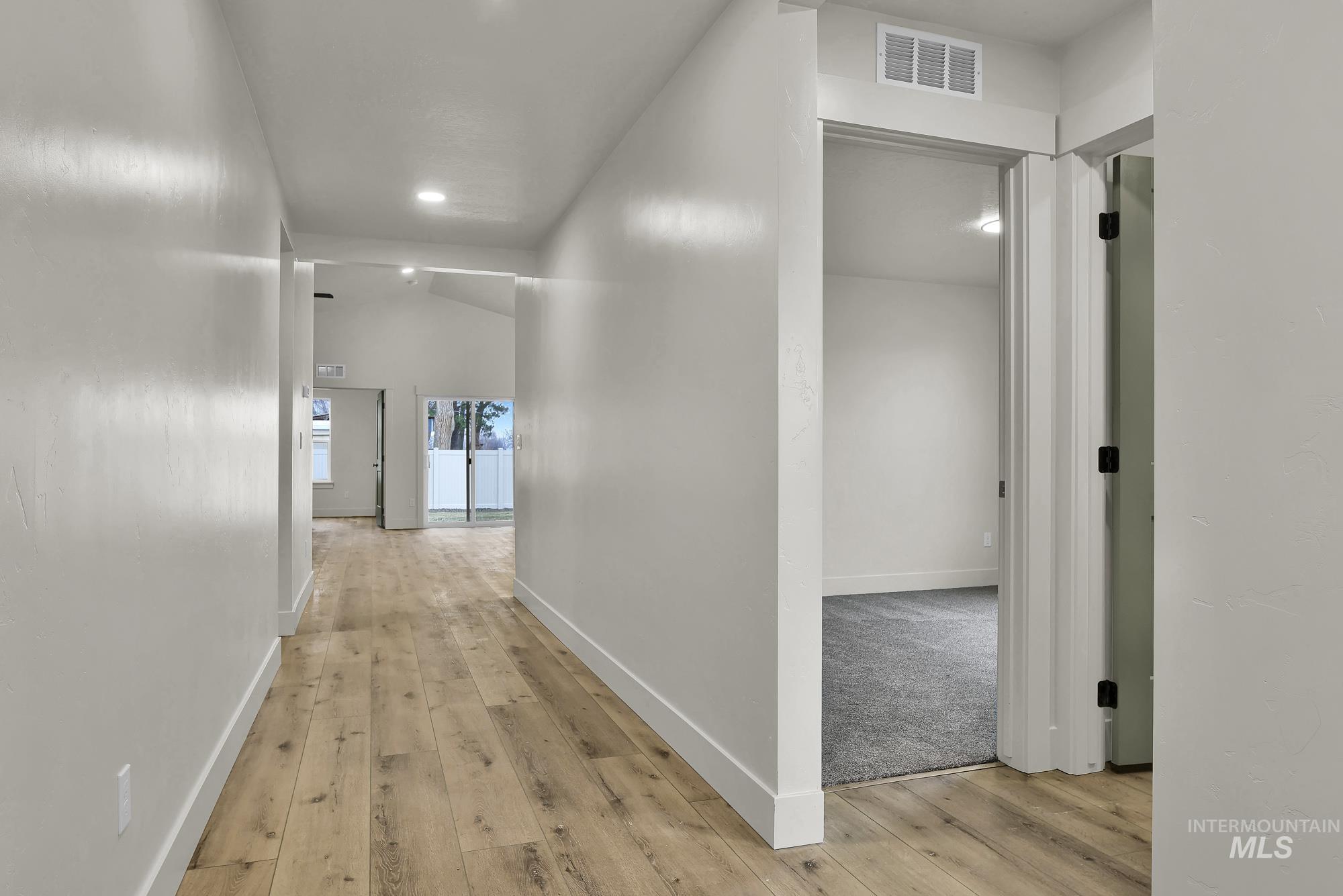 1130 Velvet Loop Wilder, ID 83676 - Photo 2 of 35 Long hallway with wood-finish flooring, white baseboards, and neutral wall paint